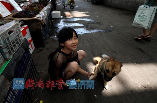 8歲的張子涵把她的小狗也帶到市場作伴