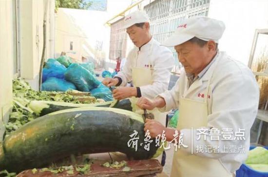 在济南金德利配送餐中心,工作人员正在进行净菜工作。