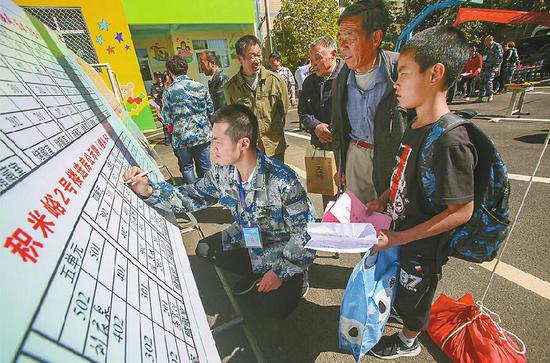 2018年9月24日中秋節(jié),王志禮扶著父親抽簽選房。