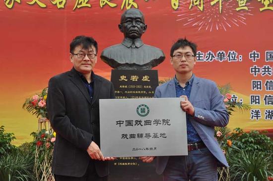 中国戏曲学院院长巴图(左)为阳信县洋湖乡中心小学授牌。