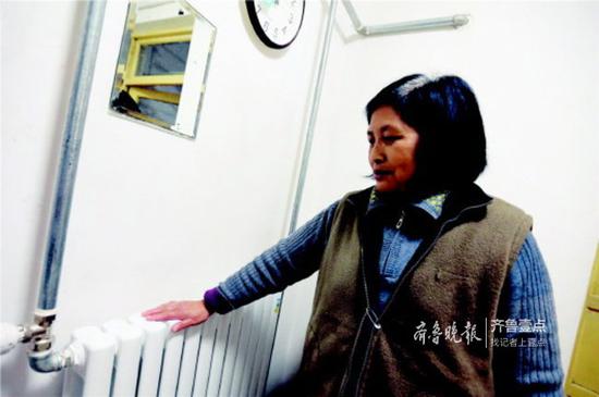 济南热电工作人员上门为居民检修暖气设施,经过检修,居民家中的暖气热了起来。