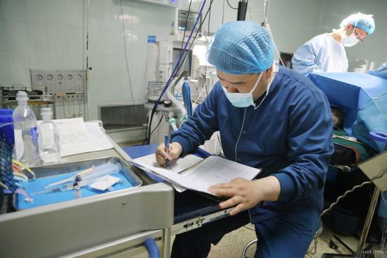 崔鵬飛在手術中做好記錄(本報記者 趙金陽 攝)