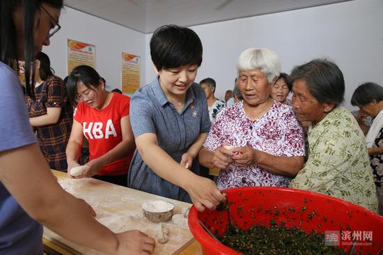 市民政局领导与工作人员和村民们一起动手包饺子。