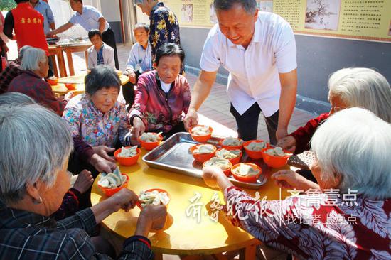孫敬民將水餃端到老人面前。
