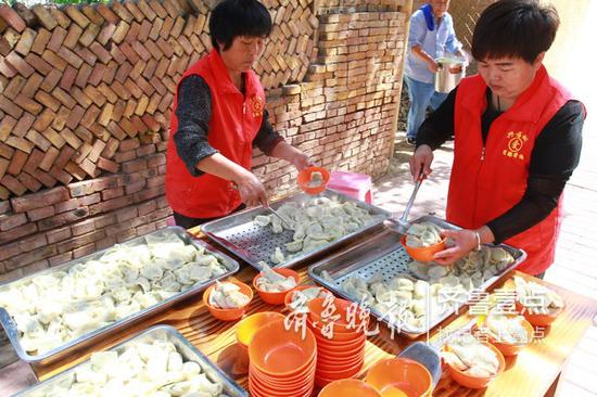 志愿者将水饺盛到碗里。