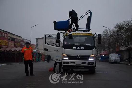 凌晨5:00,環衛工人正在運輸車中傾倒生活垃圾