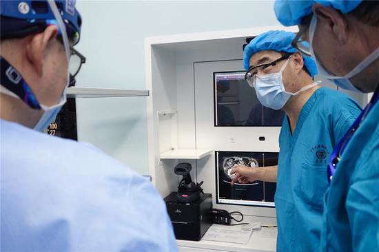 在肝移植手术开始前，臧运金（左二）和团队成员进行认真评估。
