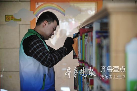 峻實正在按色標將圖書歸類上架。 齊魯晚報·齊魯壹點 記者 張中 攝