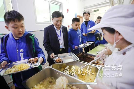 山师附小校长刘其彬与学生共同进餐。本报通讯员 王文彬 摄
