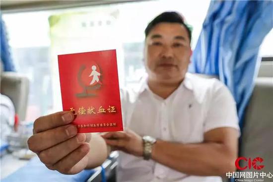 6月12日,王海軍向記者展示他的獻血證。攝影 宋海存