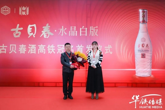 华铁传媒集团有限公司济南分公司高级经理谷媛向古贝春集团营销总监赵恩国赠送象征产品大卖的大麦花。