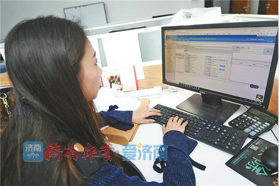 房地產企業工作人員在電腦上填寫資質申報材料。