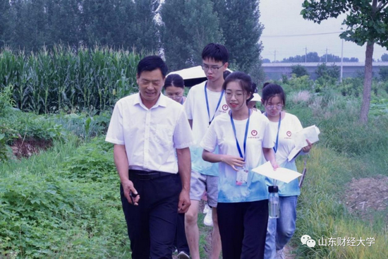 “齐鲁情”大学生支农促进会团队成员在与窦家岭村村书记交流“坑塘改造”情况