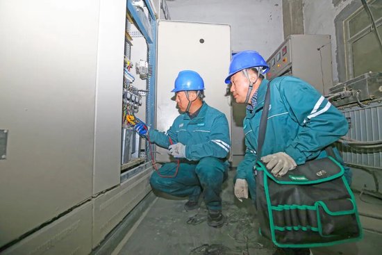 山东德州陵城区供电公司员工在金麦面业有限公司帮助企业检查配电设备。王衍 摄