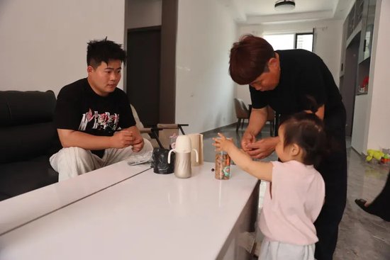 图为张健在家中陪孩子和妈妈。