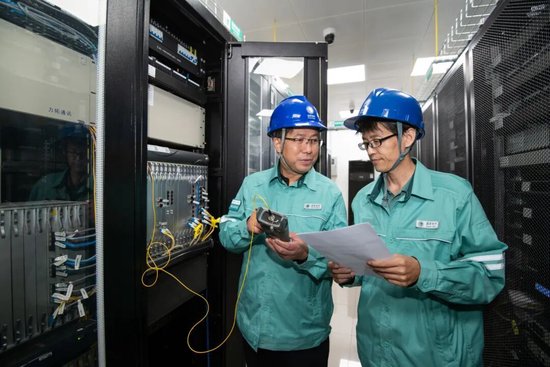 朱长青和同事在公司机房巡视检查设备