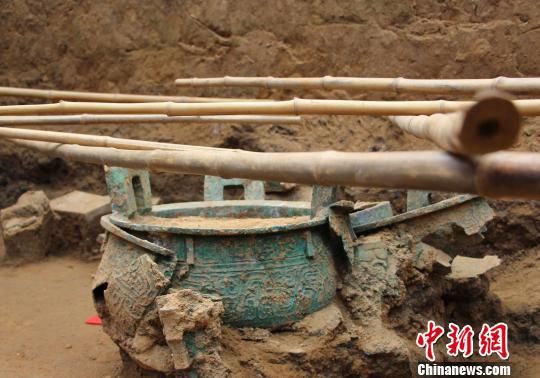 圖為考古人員在大韓東周墓地的一墓葬內發現青銅鼎。 趙曉 攝
