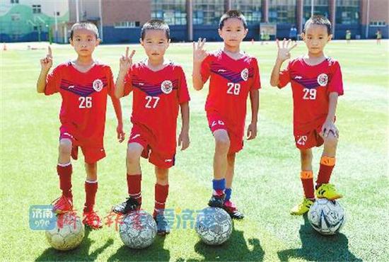 四胞胎男孩王兆弘、王兆毅、王兆嘉、王兆齊在操場踢球
