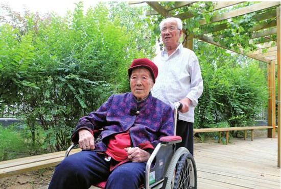 張秀珂老人推著妻子宋慶香在院子里轉(zhuǎn)轉(zhuǎn)。