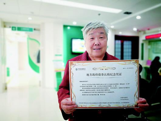 濟南市民購買到政府債券后向記者展示認購紀念憑證。(□記者 李鐵 報道)