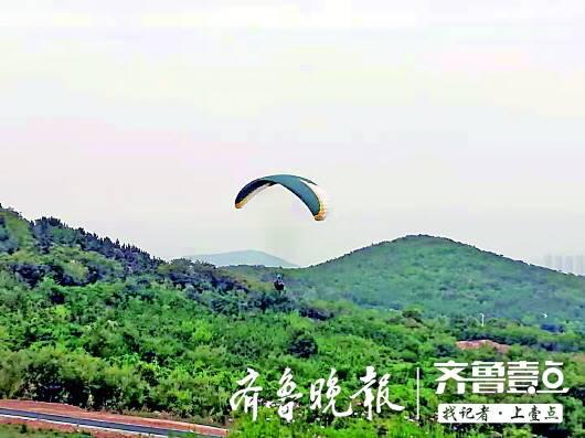 ▲7月22日,在即墨东部的四舍山,仍有滑翔伞在空中飞行。