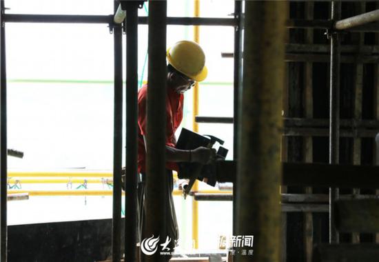 建筑工人认真固定每一块自己负责的木板