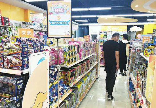 在省城東部一家綜合體兒童用品專賣店內,有家長正在挑選玩具。(張錚 攝)