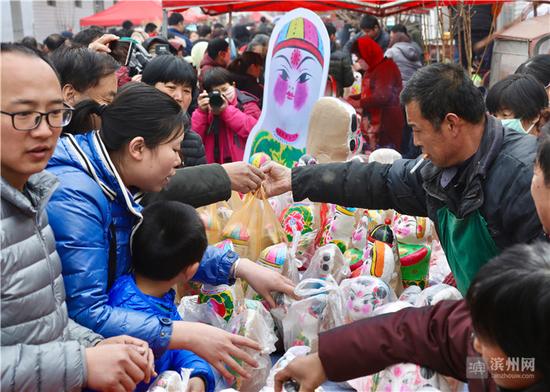 惠民河南张泥塑传承人张凯在庙会售卖自己制作的泥娃娃。