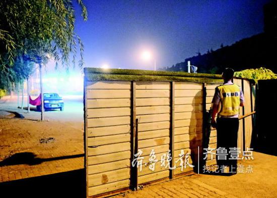 14日,交警在圍擋后面觀察路況,確定有沒有為渣土車通風(fēng)報(bào)信的車
