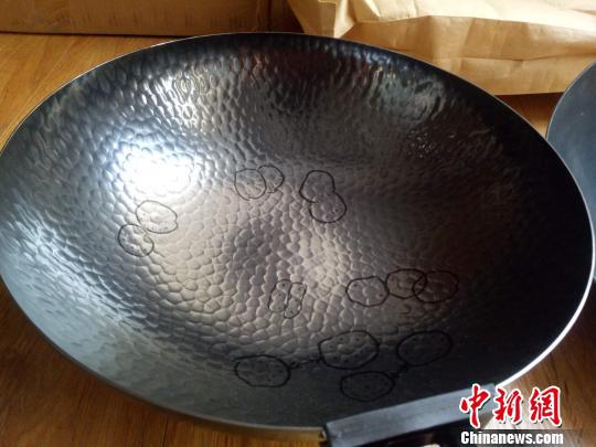 图为使用机器生产的“山寨锅”,用手能触摸到锤坑深深。 赵晓 摄