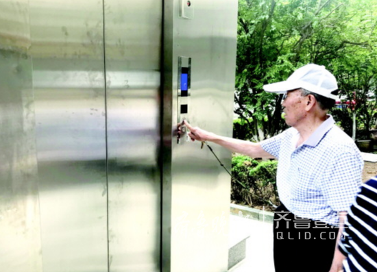 青后小区一位老人刷卡乘电梯回家。