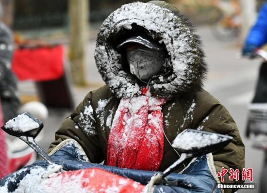 资料图：一位市民的衣帽被雪“覆盖”。 中新社记者 翟羽佳 摄