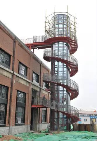 钢厂车间外面正在建设旋转楼梯,楼梯上面还有观光平台
