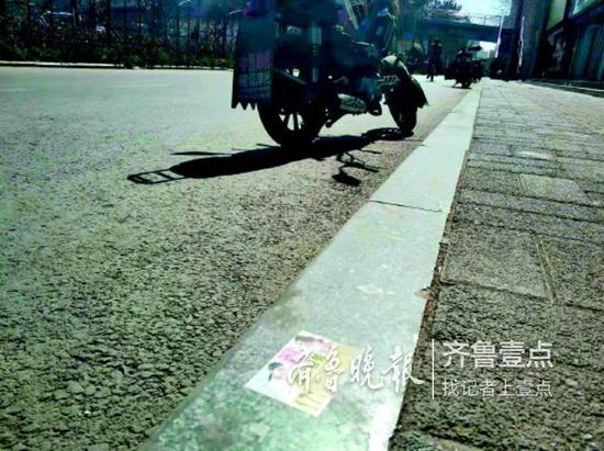 贴在地面的低俗小广告很不雅观。