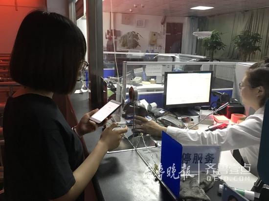 圖為大明湖站工作人員正在發(fā)售首張車票。