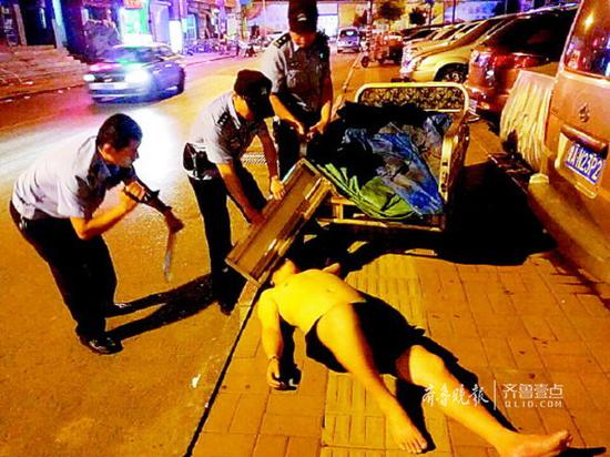 凌晨,民警救助一名醉臥街頭的男子。齊魯晚報(bào)·齊魯壹點(diǎn)記者尉偉攝