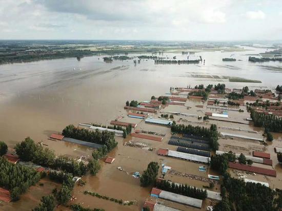 被洪水淹没的村庄和大棚。