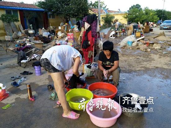 洪水退后,村民回家整理晾曬被淹的物品
