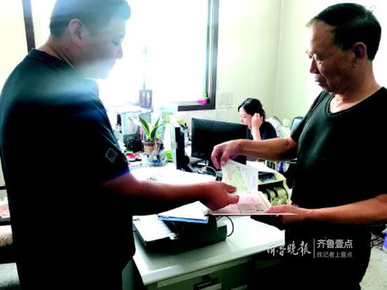 历下区住房保障和房产管理局工作人员将支票交给业主代表。