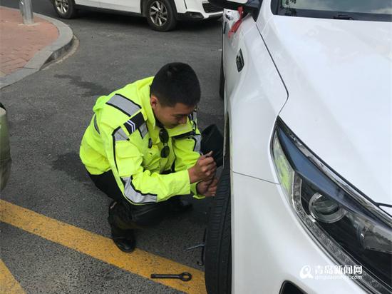 辅警张浩为市民换轮胎。