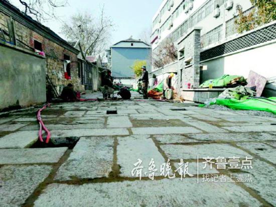 工人們用老石板重新鋪路。 齊魯晚報(bào)齊魯壹點(diǎn)記者 周青先 攝