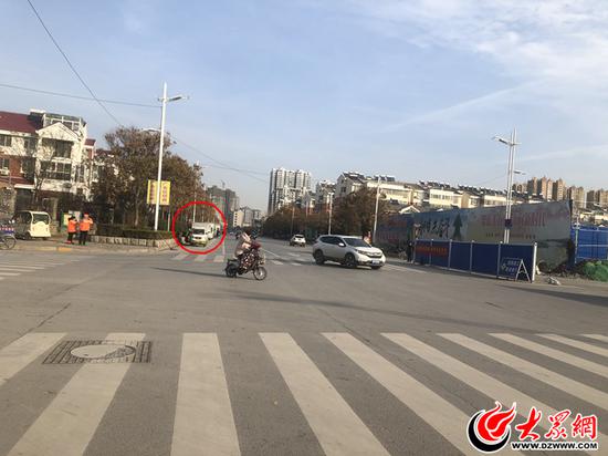 武屯路道路西侧停放了一排私家车,且路口无红绿灯