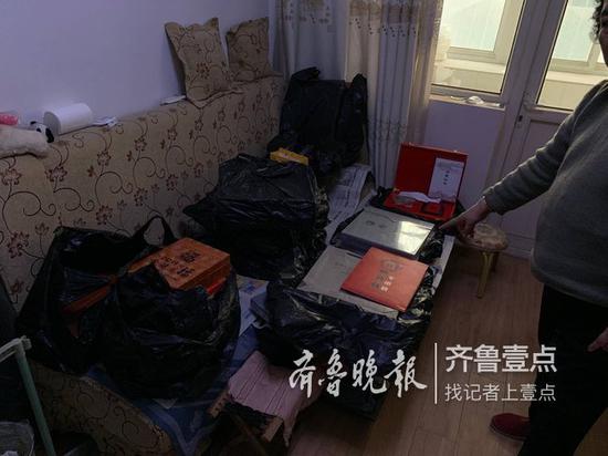 (老人家的沙发上摆满了买来的收藏品)