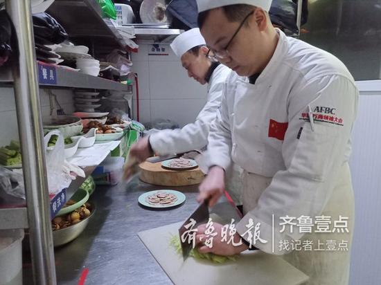 在济南传统鲁菜馆萃华楼内，厨师们正在备菜。