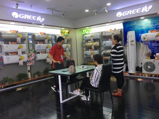 济南泉城路国美格力店,销售员在和客户沟通
