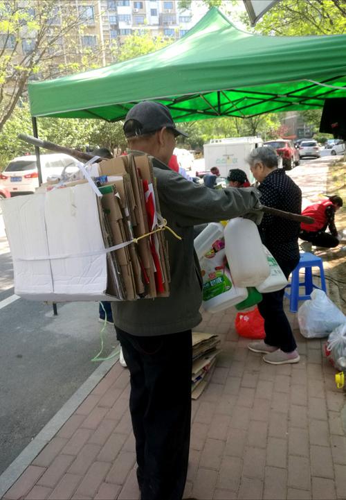 小區(qū)居民到回收點進行廢品分類處理