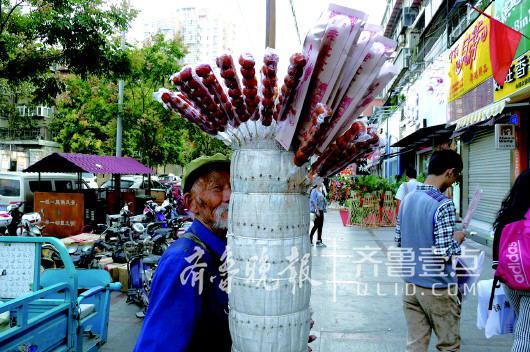 2014年,一位老人在商街上卖冰糖葫芦。
