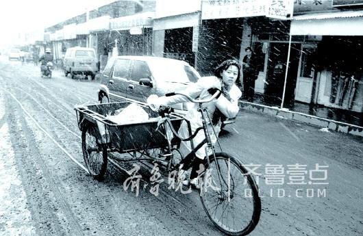 1999年1月,一位打工女孩冒着大雪推三轮车。