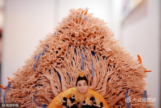 她制作的面塑工藝品—“千手觀音”,高56厘米,寬38厘米,共有觀音頭像11個,觀音手1027個。