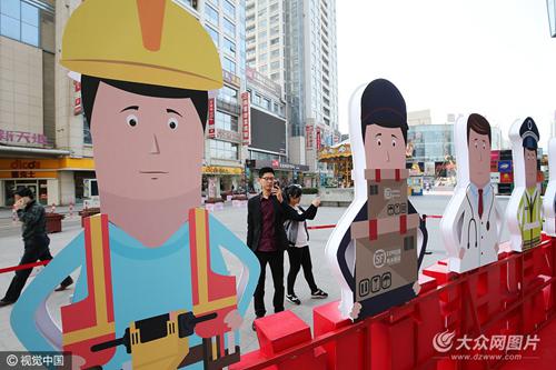 　　2017年4月28日，山东省潍坊市，“向劳动者致敬”卡通人物吸引了路人目光。
